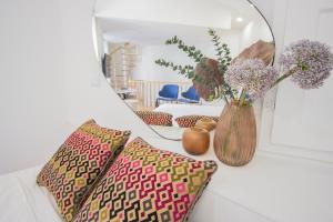 ein Spiegel auf einem Tisch mit einer Blumenvase in der Unterkunft Liceiras Apartments By Guestify in Porto