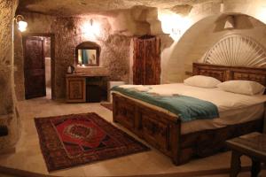 1 dormitorio con 1 cama grande en una habitación de piedra en Rose Cave Hotel en Göreme