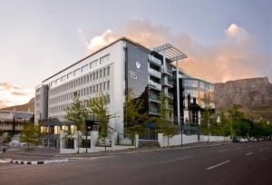 a large white building with a mountain in the background at The Capital 15 on Orange Hotel & Spa in Cape Town