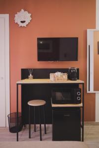 a kitchen with a counter with a microwave and a table with a stool at Casa Matilde b&b in Polistena +34 photos