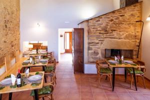 a dining room with tables and chairs and a stone wall at O Viso Ecovillage - Hotel Ecologico Vegano in Orol