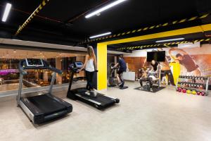 a woman is exercising on a treadmill in a gym at Ibis Poznan Centrum in Poznań