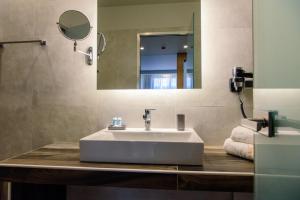a white sink sitting under a mirror in a bathroom at Eva Apartments in Piraeus