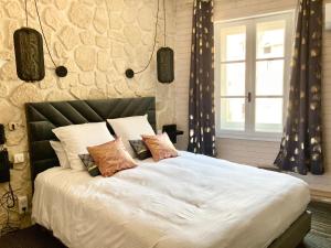 a bedroom with a large white bed with pillows at Le Sakura in Morestel