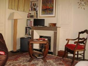 - un salon avec une table et une cheminée dans l'établissement Sylvie BARON - Composition Française - Chambres d'hôtes, à Romans-sur-Isère