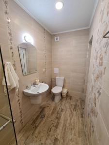 a bathroom with a white toilet and a sink at Villa Yanevi in Ravda