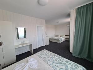 a hotel room with two beds and a mirror at Villa Yanevi in Ravda