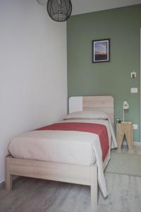 1 dormitorio con 1 cama en una pared verde en Casa Matilde b&b, en Polistena