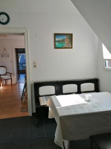 Habitación con mesa, sillas y reloj en Endes Dreiseithof - Apartment, en Schliengen