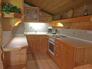 cocina con armarios de madera y encimera en Ferienwohnungen Landinger, en Aschau im Chiemgau