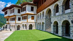 a large building with a green lawn in front of it at Guest Mansion, Гостински Палат in Rostuša