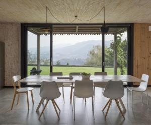 ein Esszimmer mit einem Tisch und Stühlen sowie einem großen Fenster in der Unterkunft Hemingway casa rural Kanala in Canala