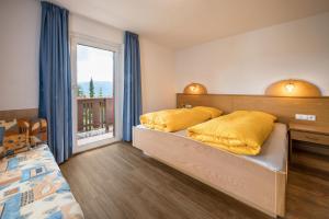 a bedroom with two beds with yellow pillows at Haus Adler in Maranza