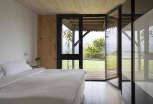 a bedroom with a bed and a large glass door at Hemingway casa rural Kanala in Canala