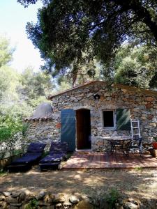 a stone cottage with a table and chairs on a deck at Cabanon Sainte Victoire in Saint-Marc-Jaumegarde