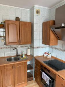 a kitchen with wooden cabinets and a sink at Apartament Aria in Ełk