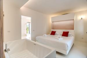 een witte slaapkamer met 2 bedden en rode kussens bij Filippo by Feeling Italy in Massa Lubrense