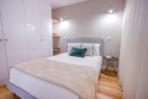 um quarto com uma cama com uma almofada verde em Santa Luzia Apartments By Guestify em Guimarães