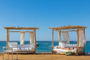 two people laying in lounge chairs on a deck at Vale Do Lobo Resort in Vale do Lobo