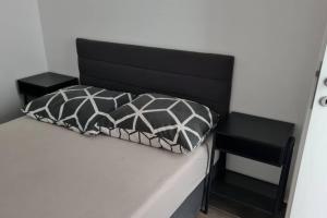 a bed with a black and white pillow on it at Mansion Duje in Brodarica
