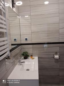 een badkamer met een wastafel en een spiegel bij HAVANA in Lublin