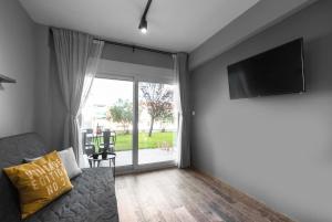 a living room with a couch and a flat screen tv at "HoMes" I, The aRt BoutiQue experience by Lou Lenny in Kallithea Halkidikis