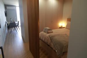 a bedroom with a bed and a dining room with a table at Sal, Terra e Mar in Aveiro