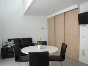 uma sala de jantar com uma mesa branca e cadeiras em Brand new apartments Ortiquattro em Milão