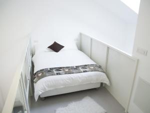 een kleine witte slaapkamer met een bed met witte lakens bij Brand new apartments Ortiquattro in Milaan