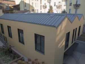 een gebouw met een metalen dak erop bij Brand new apartments Ortiquattro in Milaan