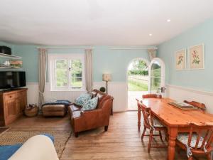 a living room with a table and a couch at Old Rectory Cottage in Sturminster Newton