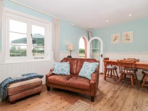 a living room with a couch and a table at Old Rectory Cottage in Sturminster Newton