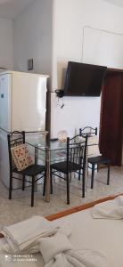 a kitchen with a glass table and chairs and a piano at Maria Charalampaki Studios in Skiros