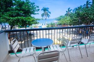 un tavolo e sedie su un balcone con vista sulla spiaggia di Apartamento Oasis a Puerto de Gaira