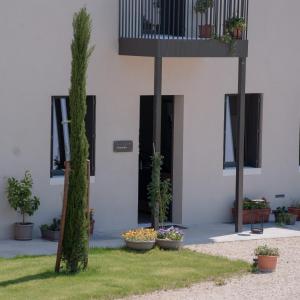 ein weißes Gebäude mit Pflanzen und einem Balkon in der Unterkunft Stilla Ristorante e Camere in Colognola ai Colli