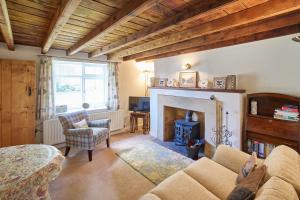 sala de estar con sofá y chimenea en Host & Stay - Grange Cottage en Osmotherley