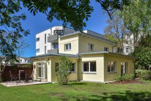 ein gelbes und weißes Haus mit einem Hof in der Unterkunft Usedom To Hus in Ahlbeck