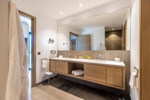 ein Bad mit einem Waschbecken und einem Spiegel in der Unterkunft Dolomitengolf Suites in Lavant