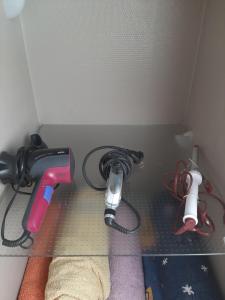 a shelf with a blow dryer and other cords at Gîte les chiwawas d'Alsace in Kaysersberg
