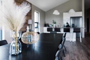 a dining room table with a vase with feathers in it at Luxury Ocean Villas in Vestmannaeyjar