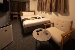 a hotel room with a bed and a chair at Coruscant Hotel NagasakiekiⅢ in Nagasaki