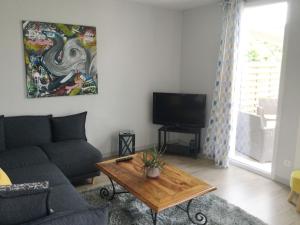 a living room with a couch and a table at Location maison Le Mans - Parking gratuit - CEMIMA in Le Mans