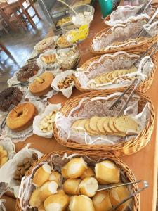 a table topped with baskets of bread and pastries at Chalé dos Alpes II em Monte Verde in Monte Verde