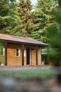 a small wooden building with a black door at The Rex in Greentown