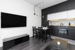 a kitchen with a dining room table and a tv at Nowa Letnica Apartments by Renters in Gdańsk