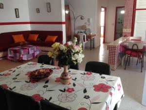 een tafel met daarop een vaas met bloemen bij Appartement Nabeul Plage in Nabeul