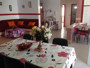 una mesa con un jarrón de flores encima en Appartement Nabeul Plage, en Nabeul