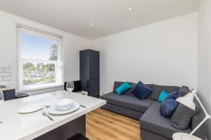 Sala de estar con sofá gris y mesa en Hazelgrove Serviced Apartment by Huluki Sussex Stays en Haywards Heath
