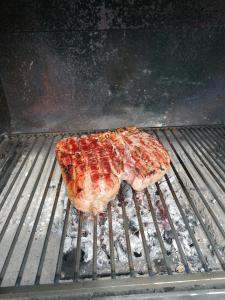 un pedazo de carne está cocinando en una parrilla en Italaforesteria en Lavone