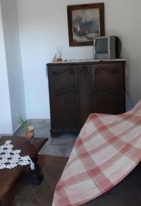 um quarto com uma cama e uma televisão num armário em Apartamento no centro em São Lourenço